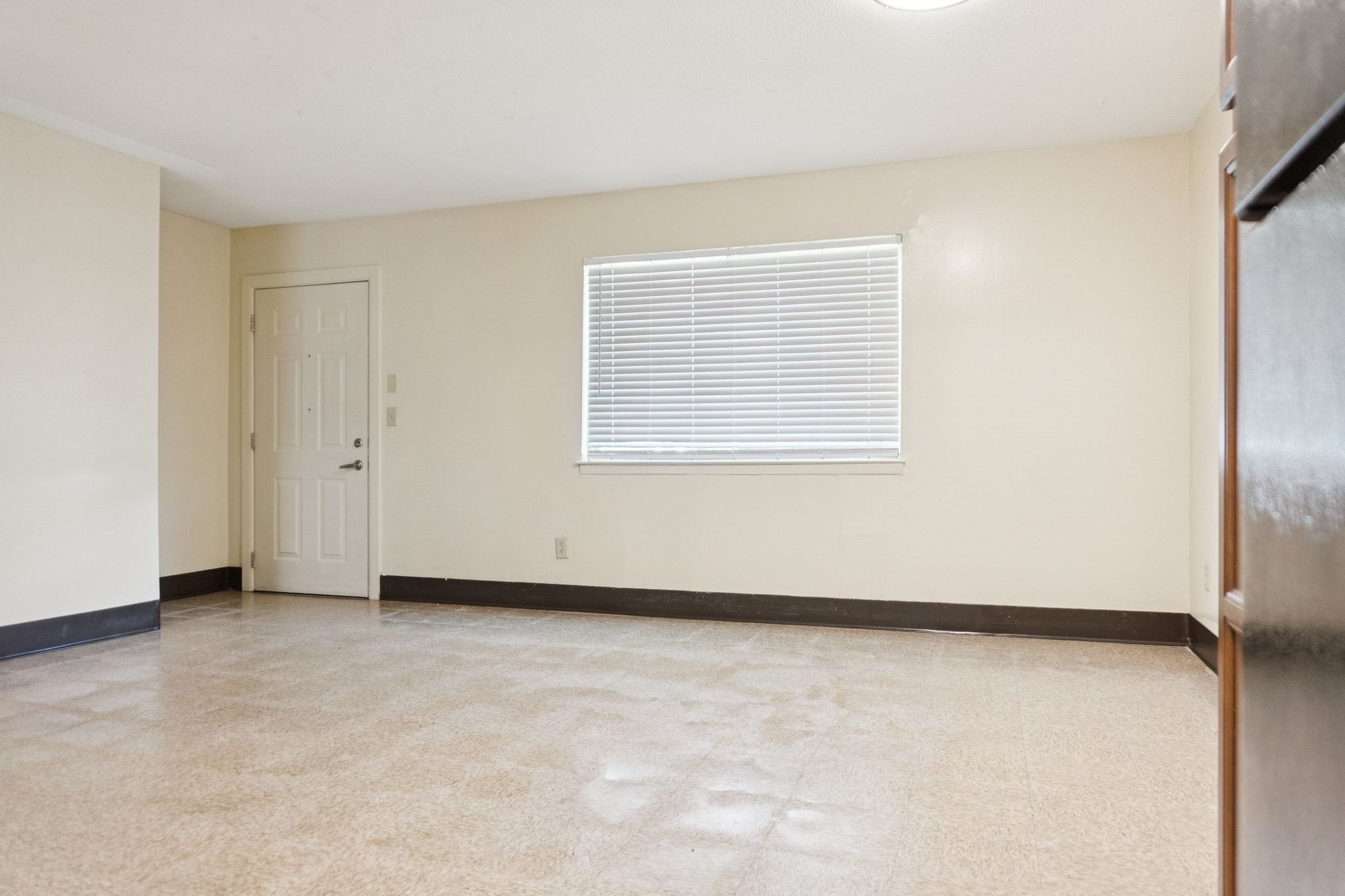 A room with a door, window, and tiled floor.